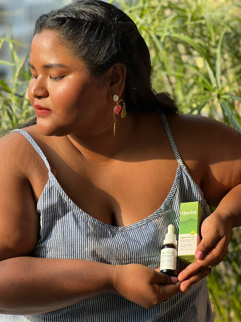 A Qurist customer holding CBD and THC oil outdoors